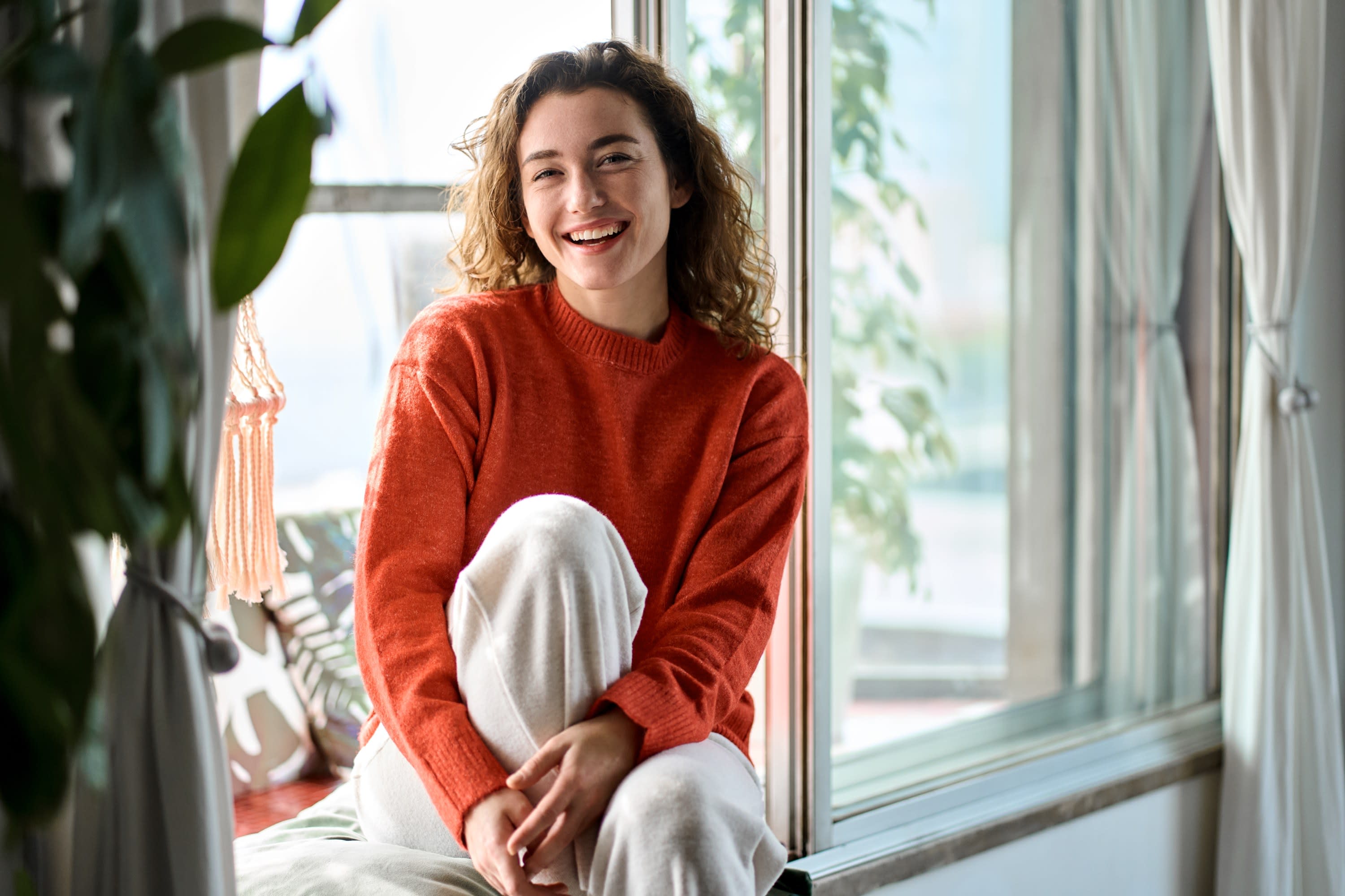 A young woman relaxing by a sunny window