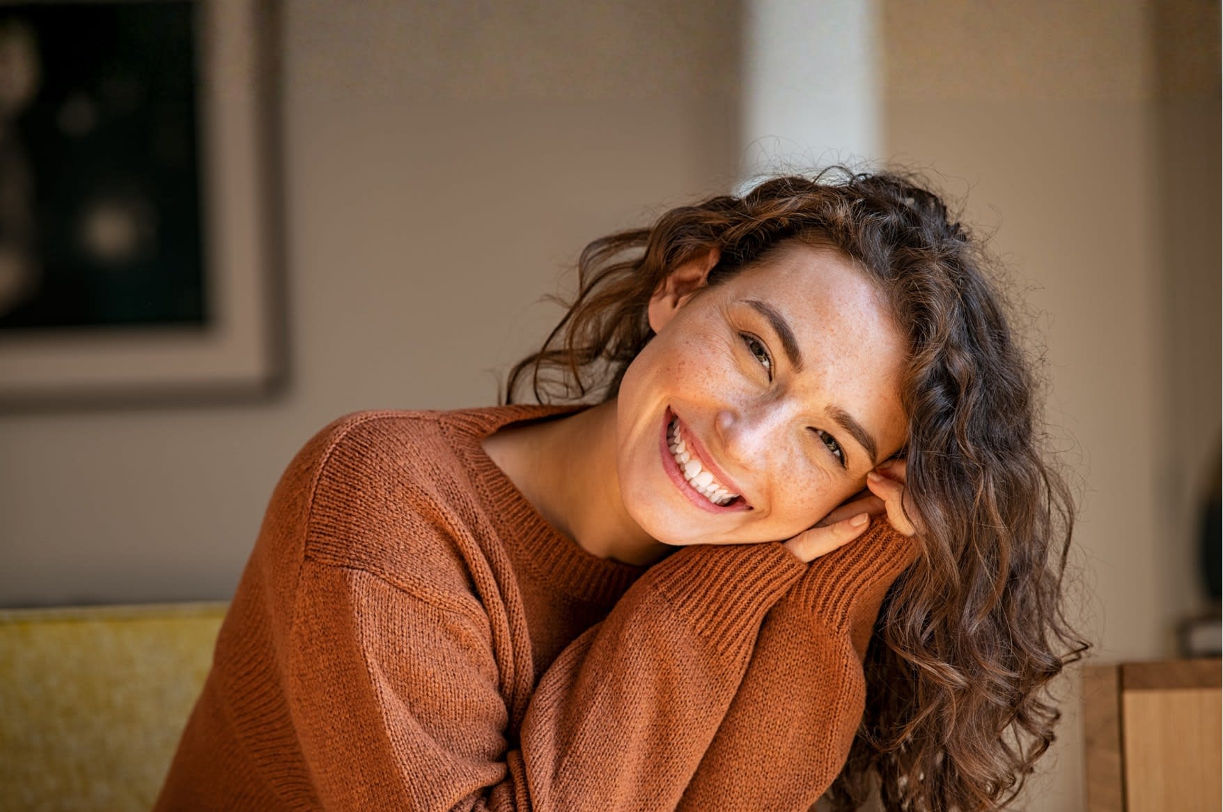 A young woman smiling warmly, feeling supported and connected