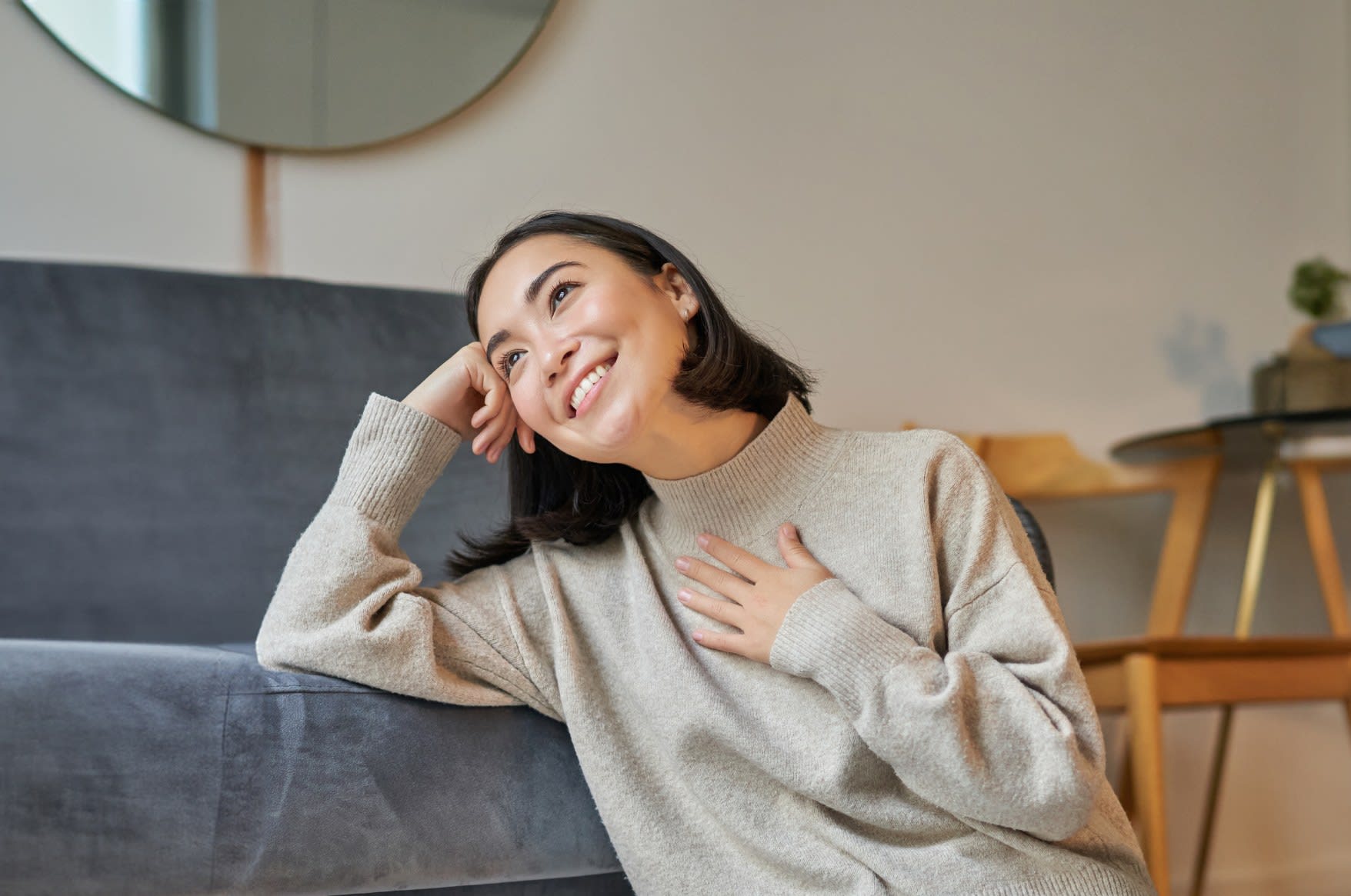 A young woman smiling in bright, natural light
