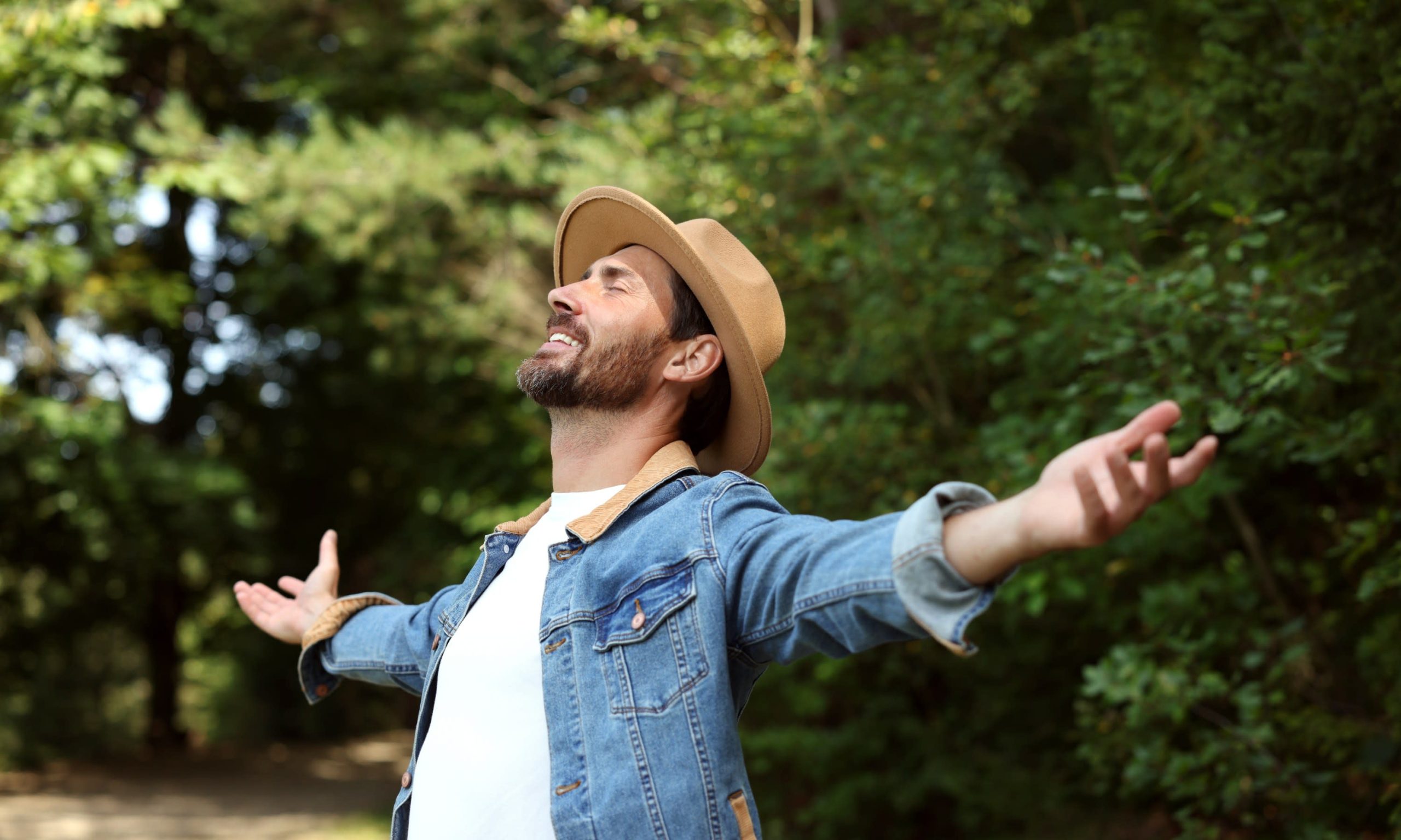 A person with open arms in nature